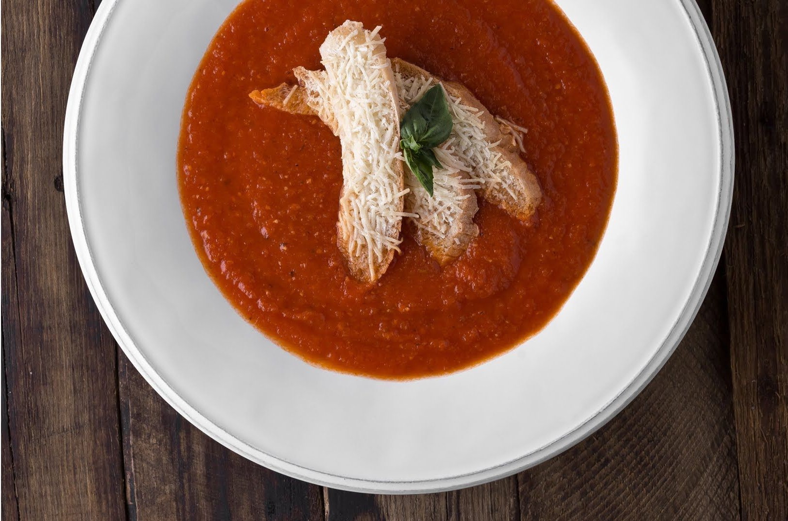 Cream Of Tomato Soup With A Slice Of Warm Bread And Pecorino Cheese